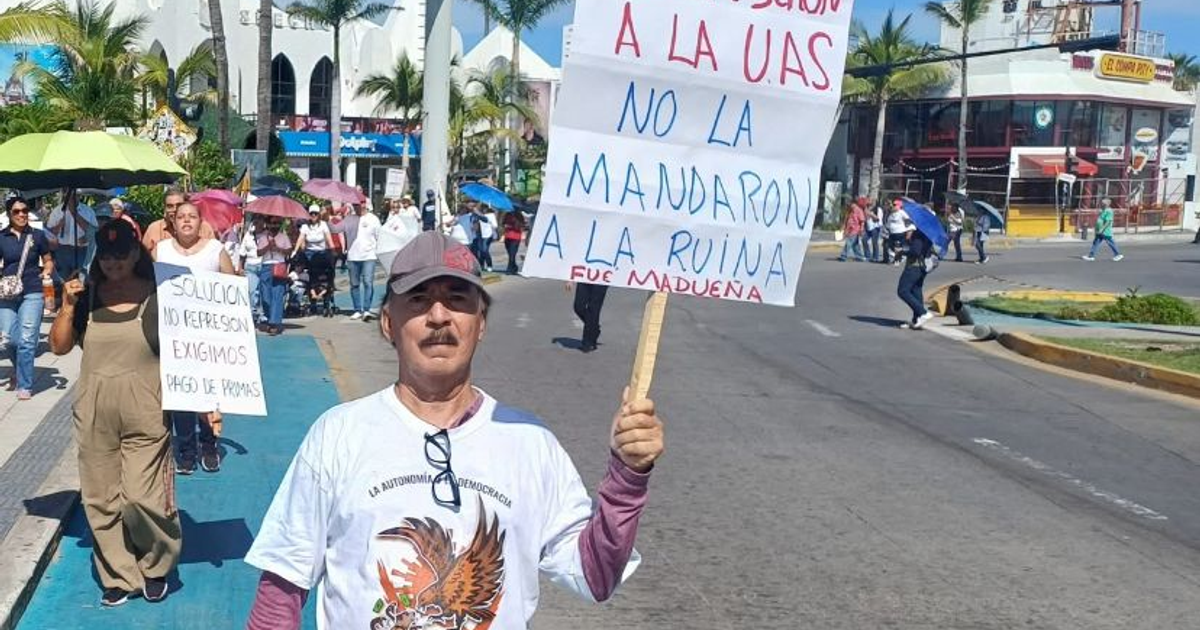 Manifestación de trabajadores y jubilados de la UAS en Mazatlán con carteles de protesta.