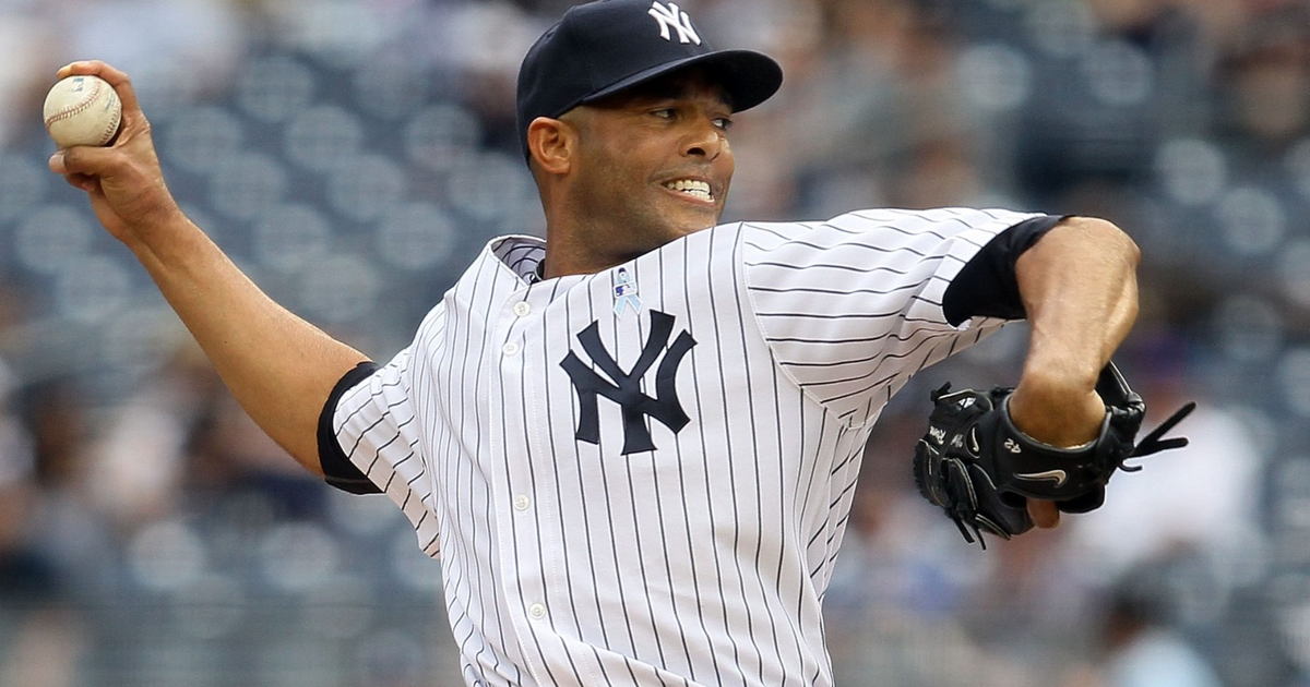 Jugador de los Yankees lanzando en un estadio lleno durante un partido crucial