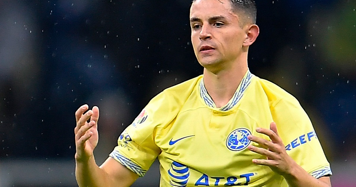 Jugador de fútbol con camiseta amarilla en partido lluvioso