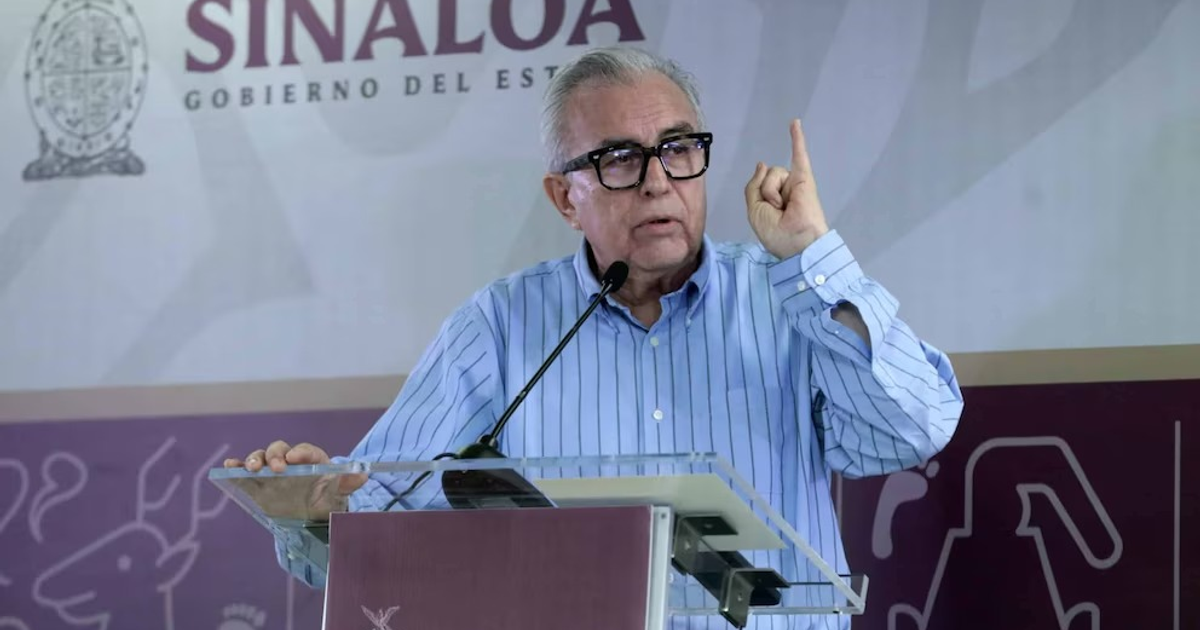Gobernador Rubén Rocha Moya hablando en un atril con el logo de Sinaloa de fondo