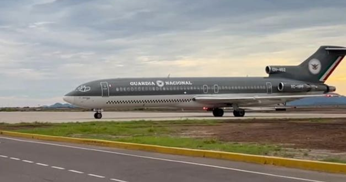 Avión de la Guardia Nacional en pista de aterrizaje con montañas y cielo nublado de fondo.