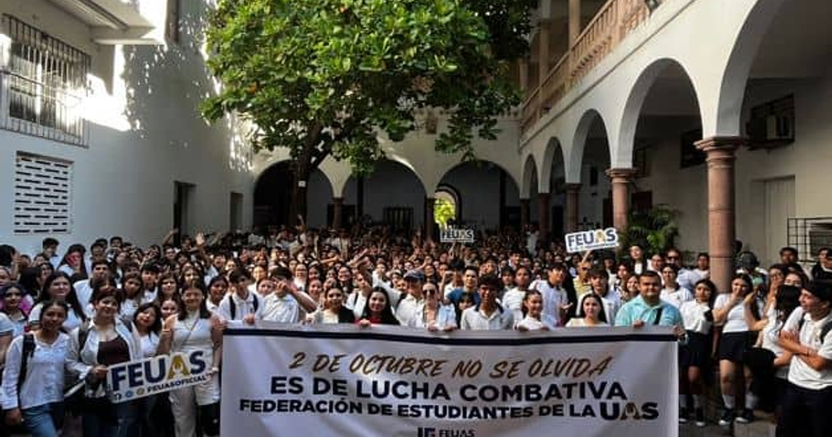 Estudiantes de la FEUAS conmemoran el 2 de octubre en el campus universitario, sosteniendo pancartas y banderas.