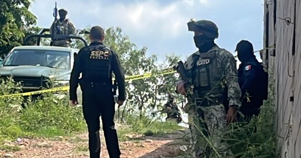 Agentes de seguridad en escena de crimen en Los Ciruelos, Sinaloa, con vehículo verde y cinta de policía.