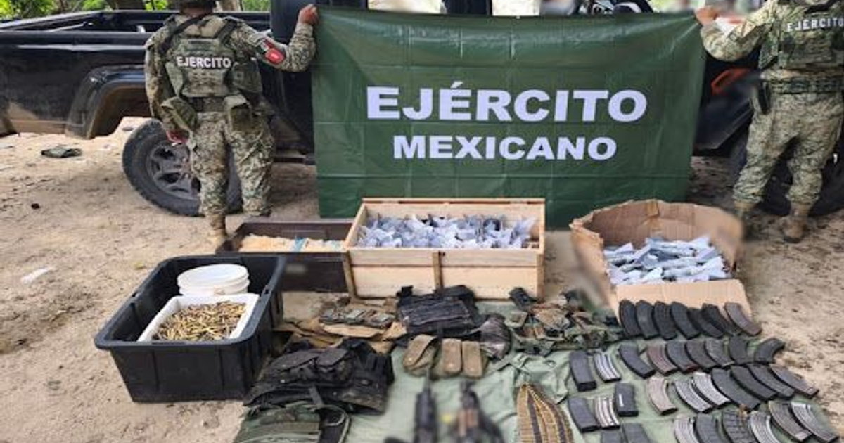 Miembros del Ejército Mexicano junto a un cartel y cajas de municiones durante un operativo en Badiraguato.