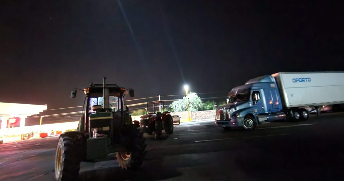 Estacionamiento nocturno con tractores y camión de carga en Guasave, relacionado con el bloqueo de agricultores.