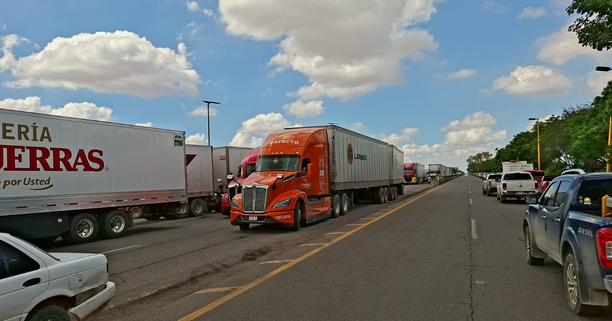 Carretera en Guasave con camiones de carga aparcados por bloqueo en caseta de Cuatro Caminos