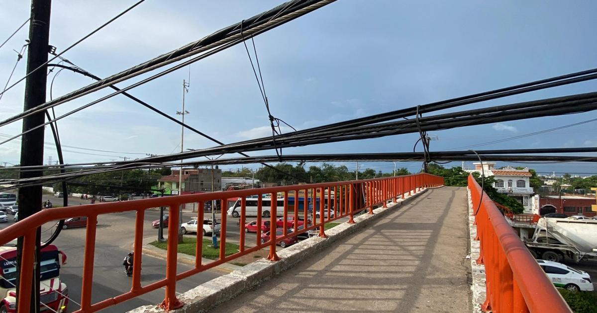 Vista desde un puente peatonal en Mazatlán con cables aéreos y tráfico vehicular