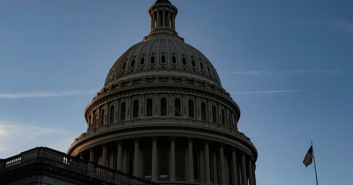 Cúpula de edificio gubernamental con cielo azul y asta de bandera, representando el cierre del gobierno en EE.UU.