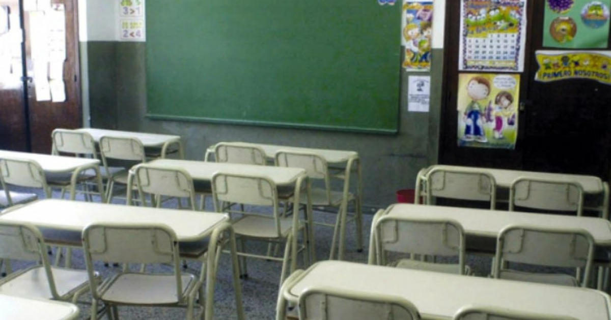Aula escolar con escritorios, sillas y pizarra verde en Culiacán, reflejando la educación intermitente por violencia.