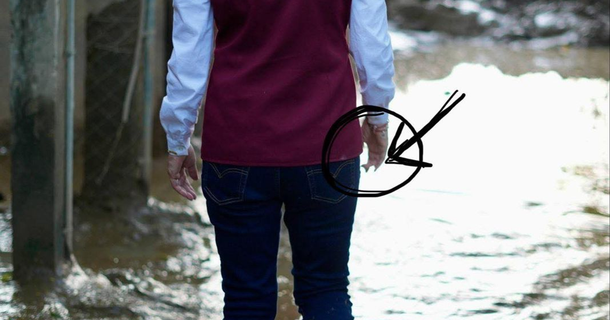 Persona de espaldas con chaleco burdeos en zona inundada, en medio de controversia por ediciones con IA.