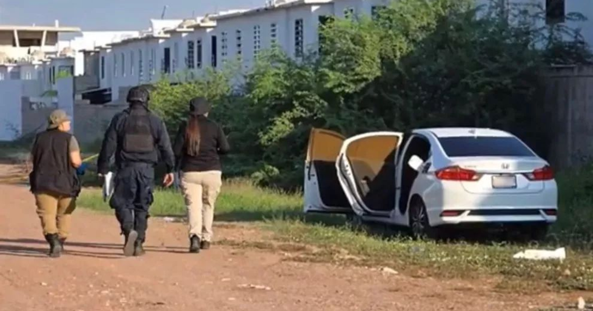 Tres personas, una con uniforme táctico, junto a un auto blanco en un camino de tierra en Culiacán.