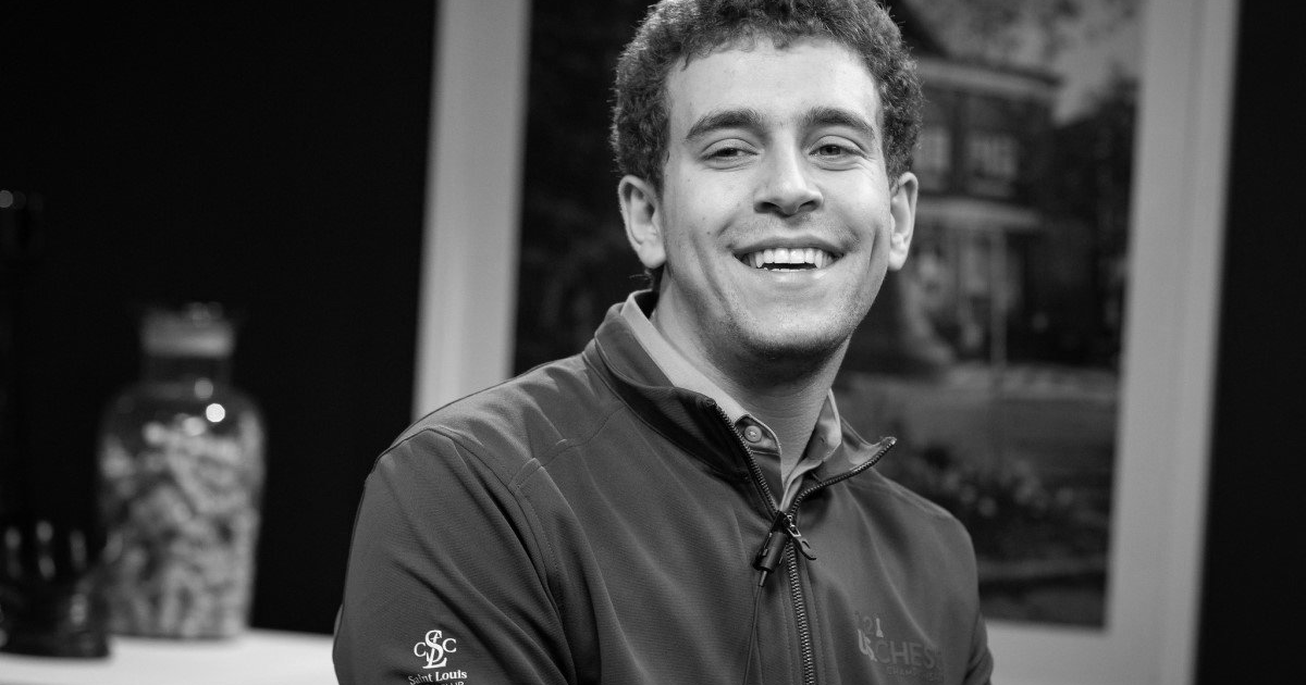 Persona sonriendo en un entorno acogedor, evocando a Daniel Naroditsky.