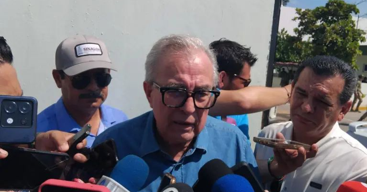 Gobernador Rubén Rocha Moya en conferencia de prensa sobre la desaparición de Carlos Emilio en Sinaloa, rodeado de periodistas.