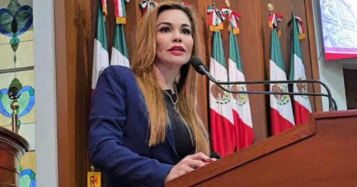 Diputada del PRI en el Congreso de México con banderas de fondo