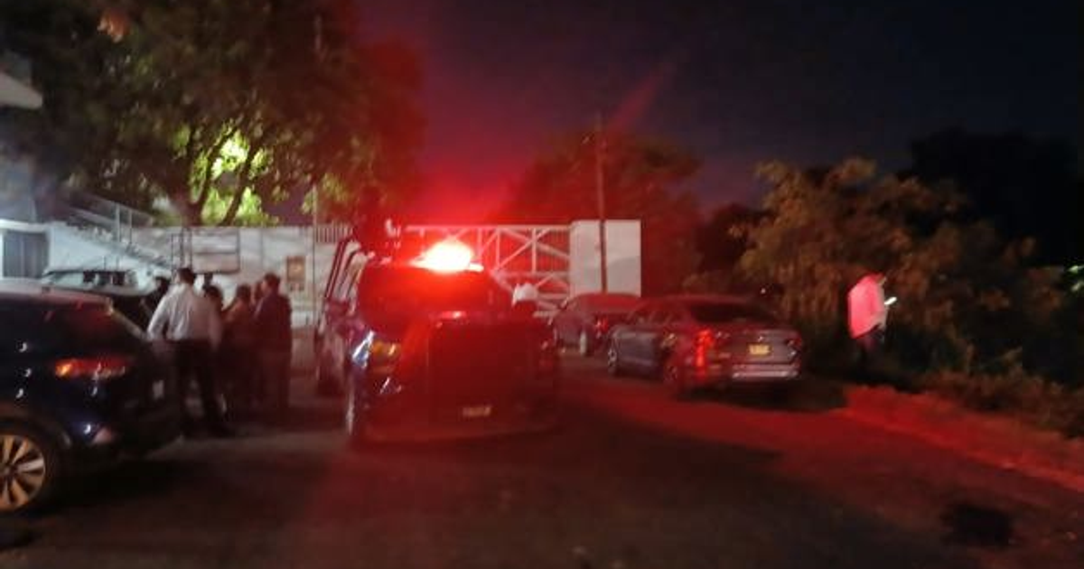 Escena nocturna en Culiacán con vehículos y personas tras un incidente violento