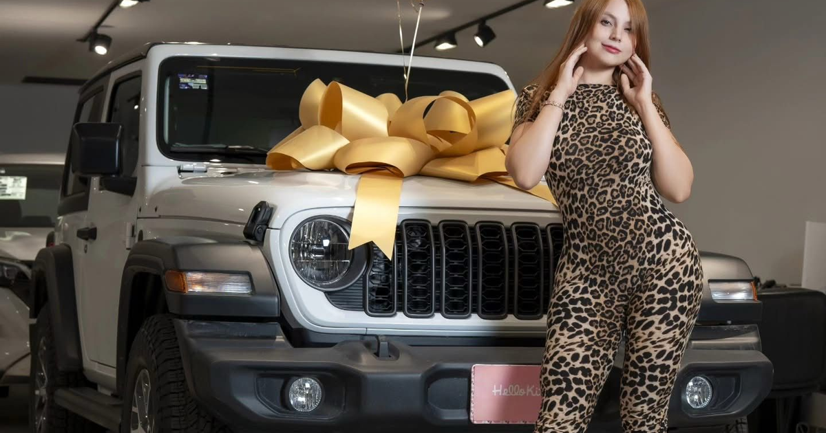 Emilia Vizcarra en traje de leopardo frente a un auto blanco con lazo dorado