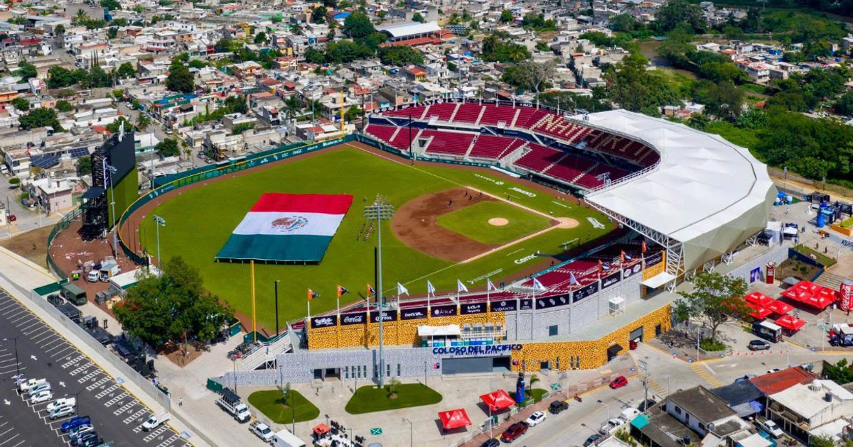 Estadio de béisbol 'Coloso del Pacífico' en Tepic durante su inauguración, con bandera de México y gradas rojas.
