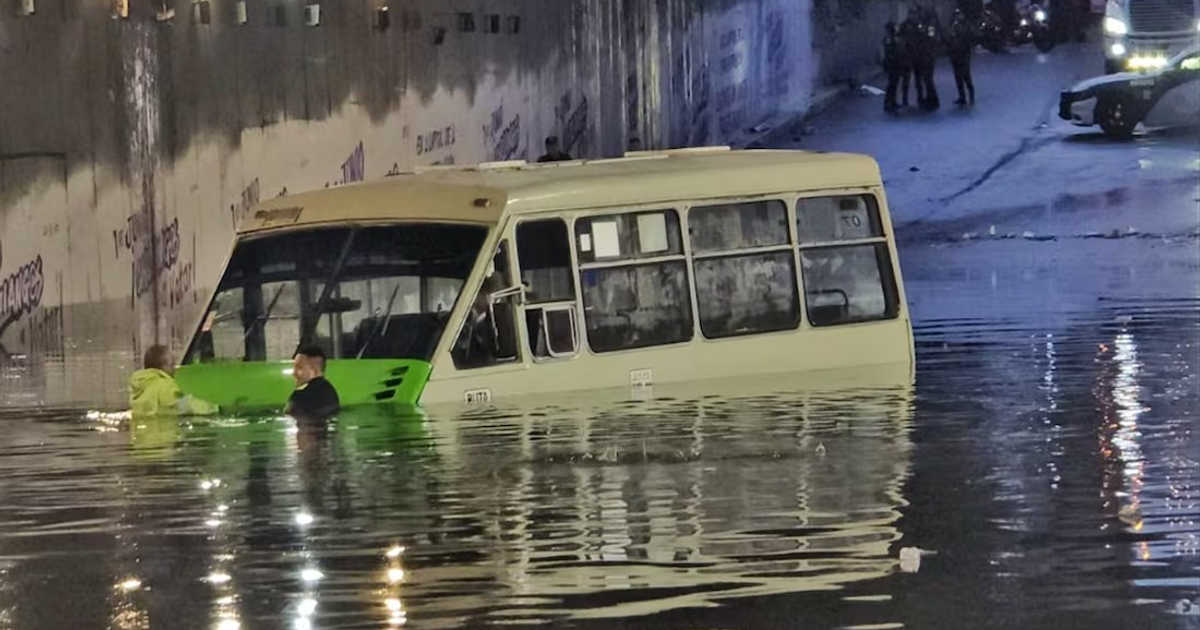 Autobús sumergido en túnel inundado con rescatistas en acción