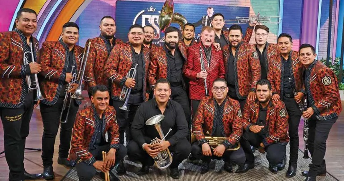 Banda Estrellas de Sinaloa posando con instrumentos musicales en un set de grabación.