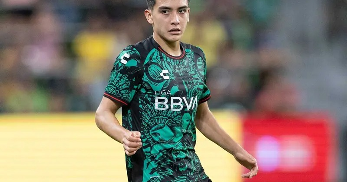 Jugador de fútbol con camiseta verde en movimiento durante un partido