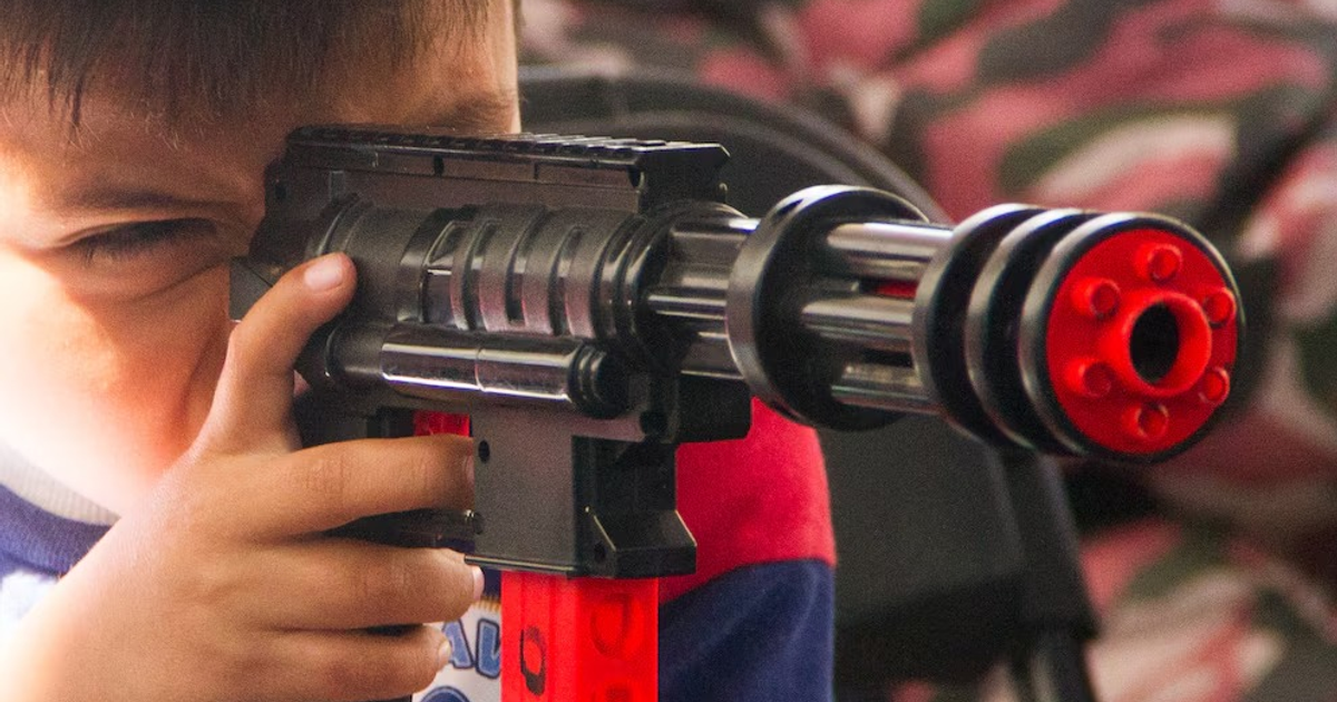Niño jugando con réplica de arma en un entorno recreativo