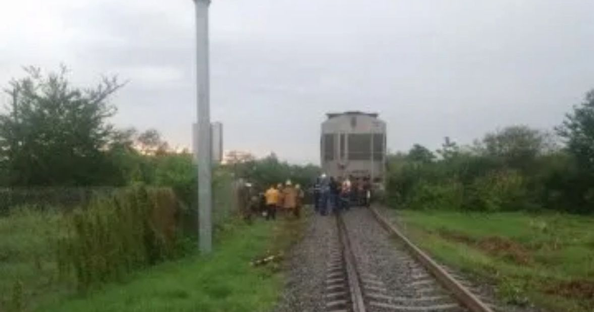 Personas reunidas cerca de un tren detenido en un área verde con cielo nublado, relacionado con un accidente en Culiacán.