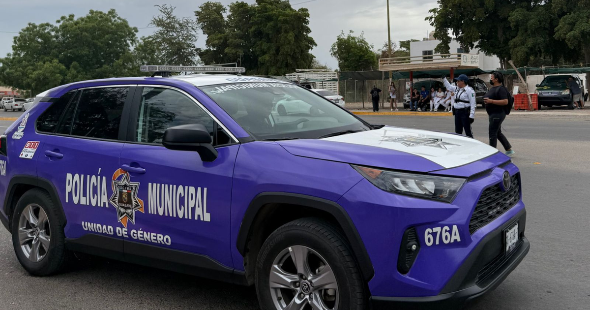 Vehículo de la Policía Municipal de la Unidad de Género en un entorno urbano, con una oficial interactuando con un transeúnte.