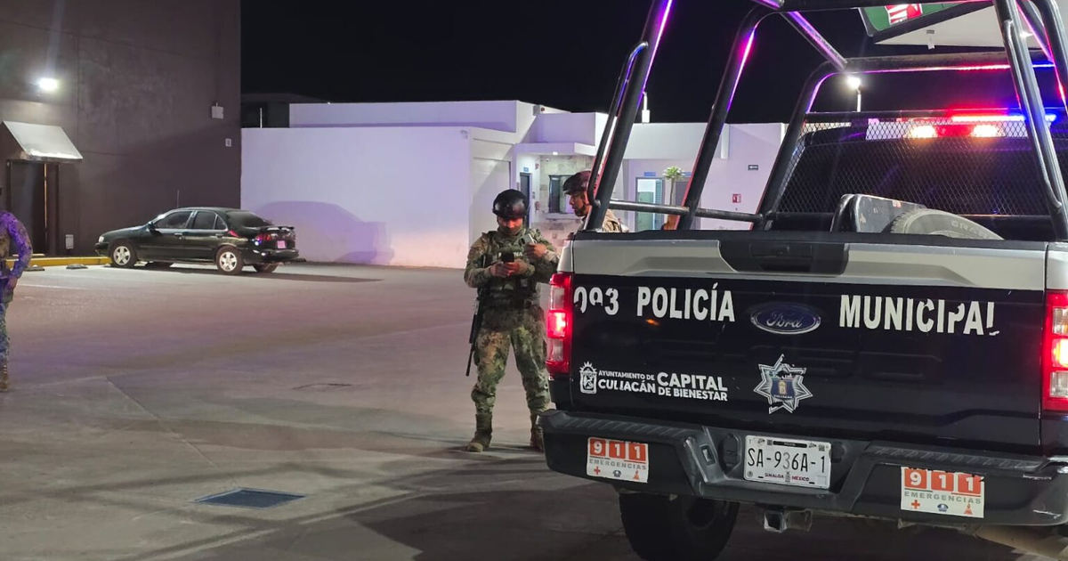 Vehículo de policía municipal en escena nocturna urbana con dos oficiales presentes.