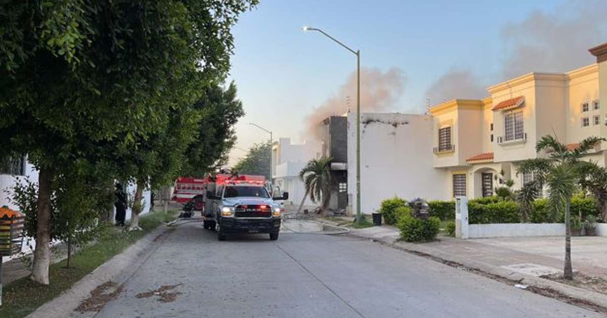 Camión de bomberos en calle residencial de Culiacán con humo saliendo de un edificio
