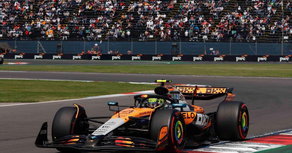 Coche de Fórmula 1 en pista durante el Gran Premio de México con espectadores en las gradas.