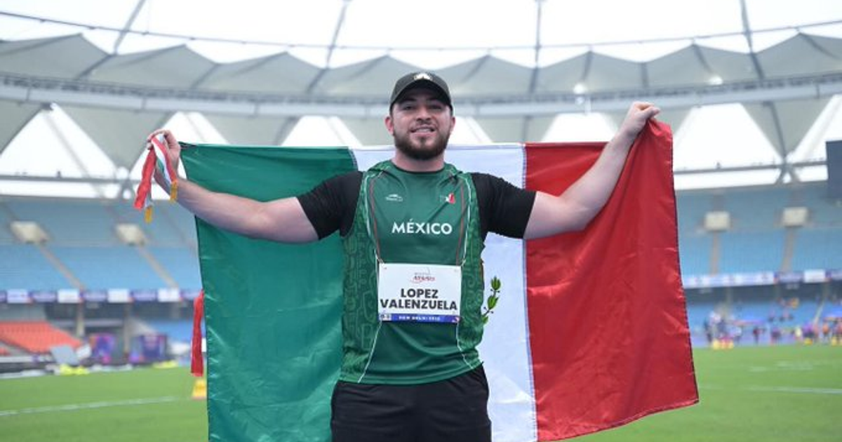 Luis Carlos López con la bandera de México tras ganar oro en lanzamiento de disco F37
