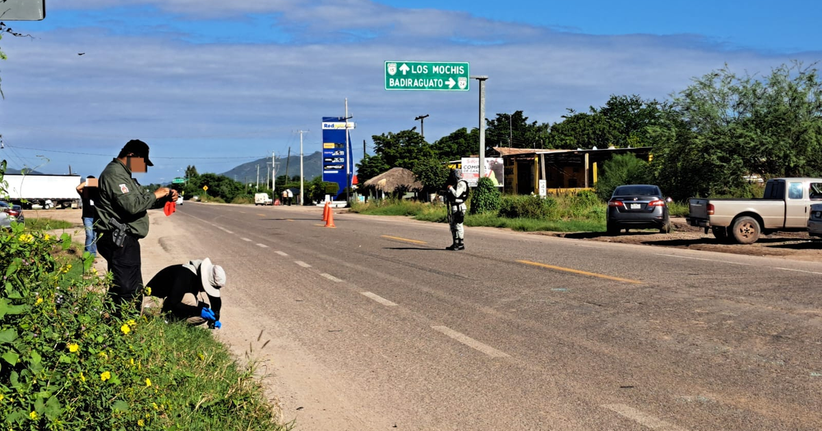 Carretera con señalización hacia Los Mochis y Badiraguato, escena de accidente con vehículos y personal de seguridad.