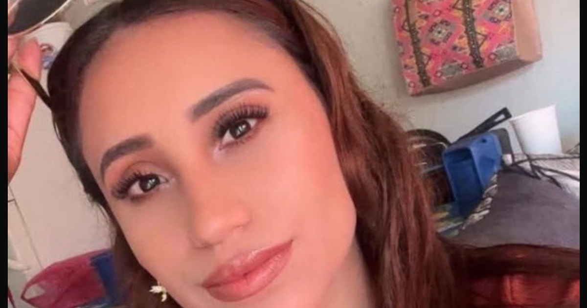 Retrato de una mujer sonriendo con cabello largo, fondo con objetos y bolsa decorativa.