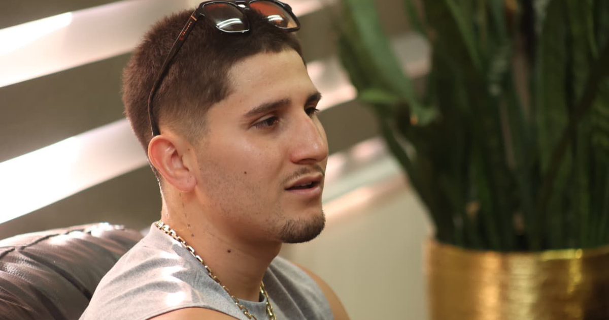 Marco Verde reflexionando antes de su pelea en Mazatlán, con gafas de sol y planta de fondo.