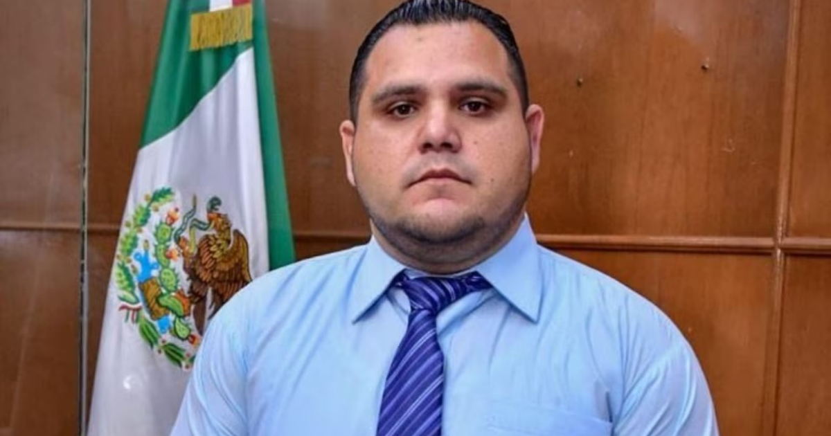 Jaime Othoniel Barrón Valdez en conferencia sobre delincuencia juvenil, con bandera de México de fondo.