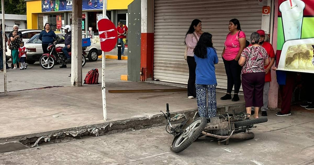 Motocicleta caída en una calle de Los Mochis, con personas y vehículos alrededor.