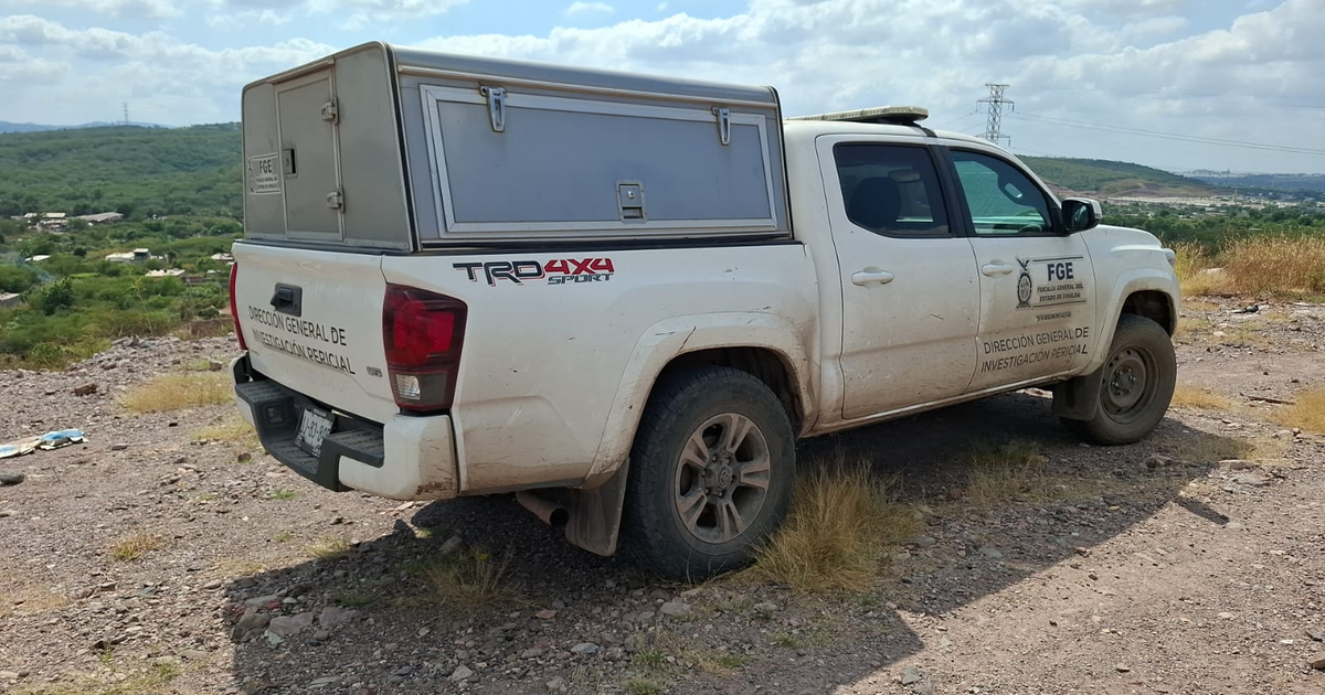 Camioneta blanca de investigación en área rural con colinas al fondo