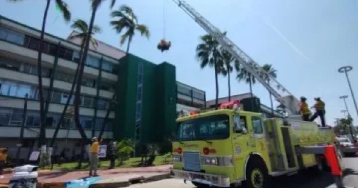 Camión de bomberos amarillo con escalera elevadora en Mazatlán, Sinaloa, durante un día soleado.