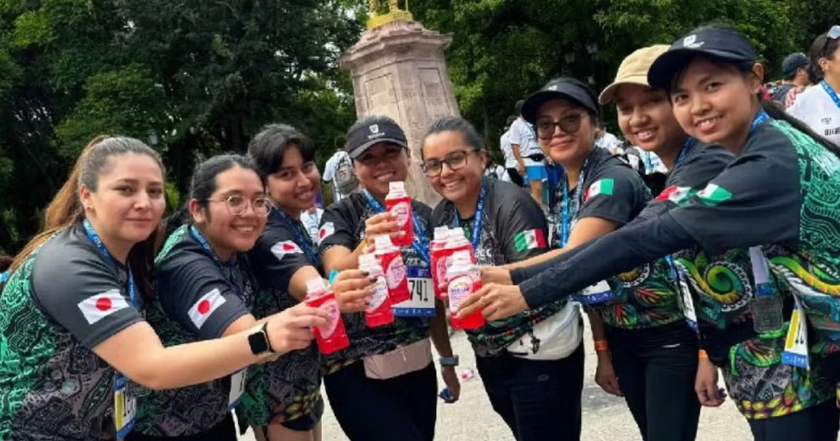 Grupo de mujeres celebrando con bebidas en evento deportivo, destacando la importancia de sueros orales para la rehidratación.
