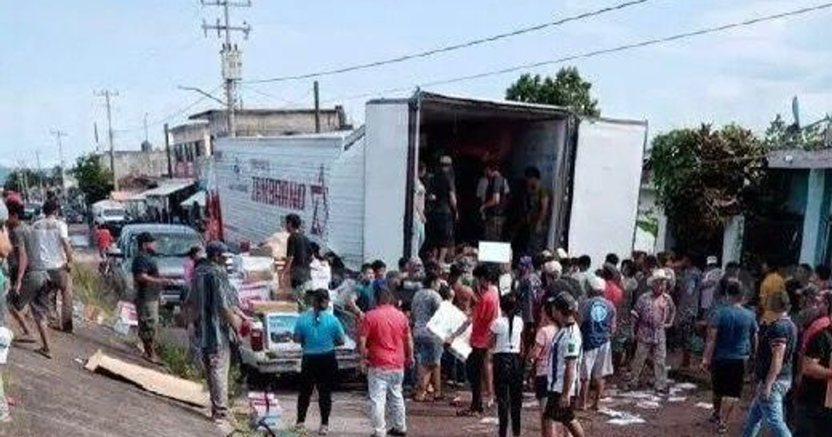 Grupo de personas alrededor de un camión en la carretera México 15, tras un desperfecto en la caja del tráiler.