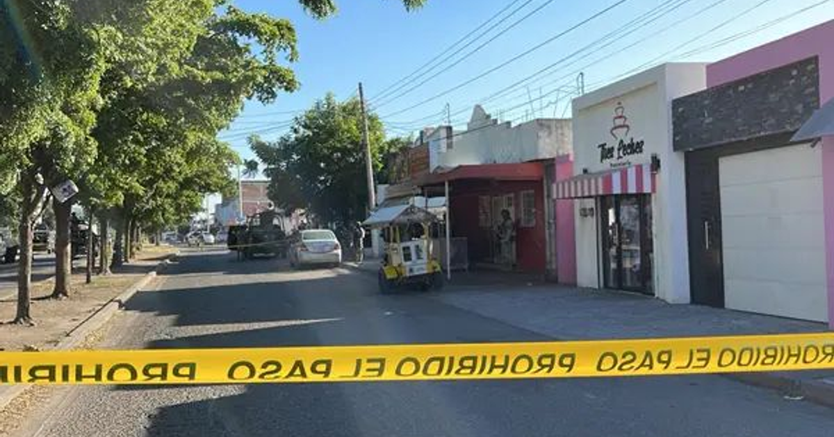 Calle urbanizada en Culiacán con cinta de seguridad y letrero de 'prohibido el paso'.