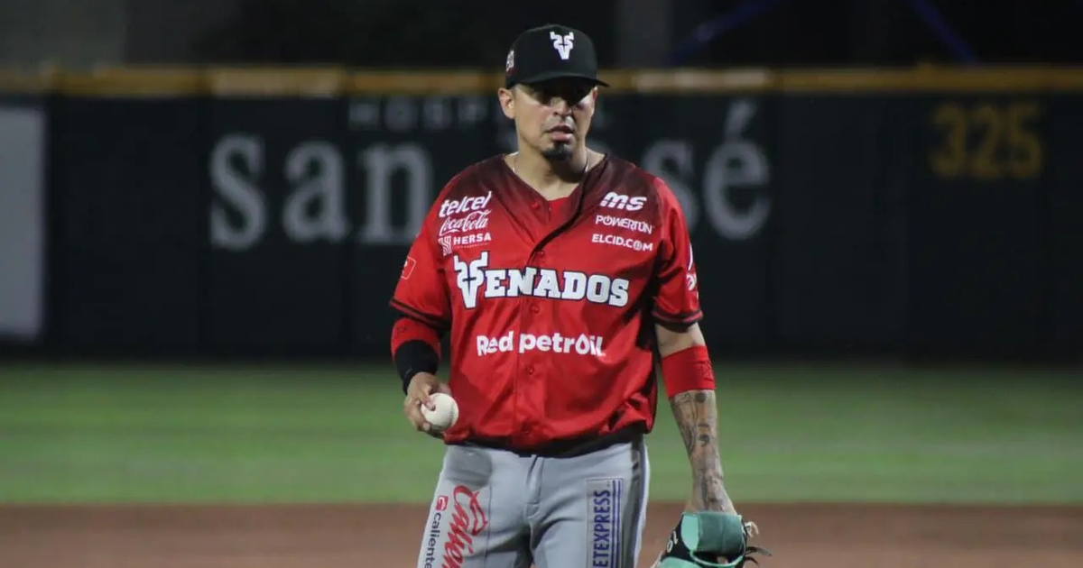 Jugador de béisbol de Venados de Mazatlán con uniforme rojo sosteniendo una pelota y un guante en el campo.