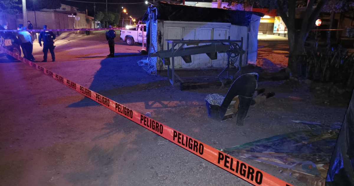 Escena nocturna de investigación policial en Guamúchil con cinta de advertencia y vehículos de policía.