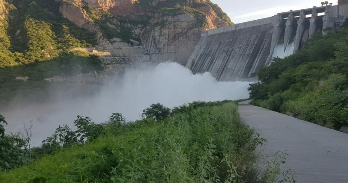 Represa en Sinaloa con agua fluyendo y montañas al fondo