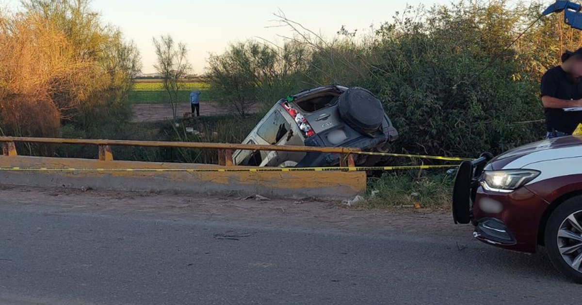 Vehículo volcado en canal con policía y cintas de precaución en el ejido 1 de Mayo, Ahome.