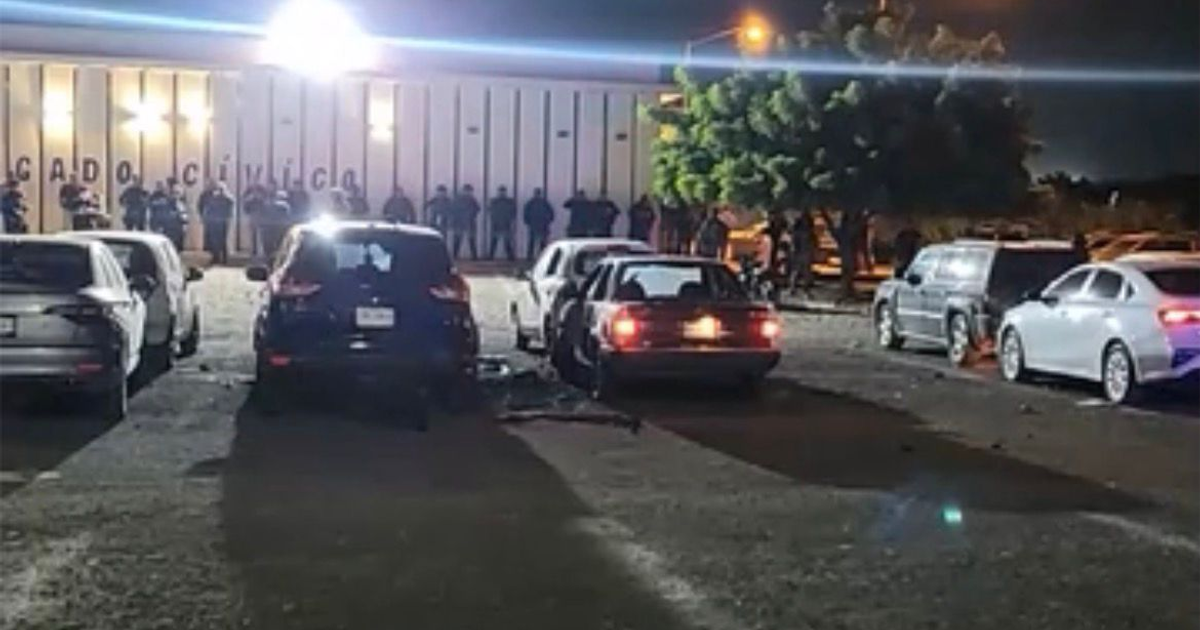Policías alineados frente al edificio CIVIL tras explosión en el estacionamiento del Centro de Seguridad Ciudadana de Mazatlán, de noche.