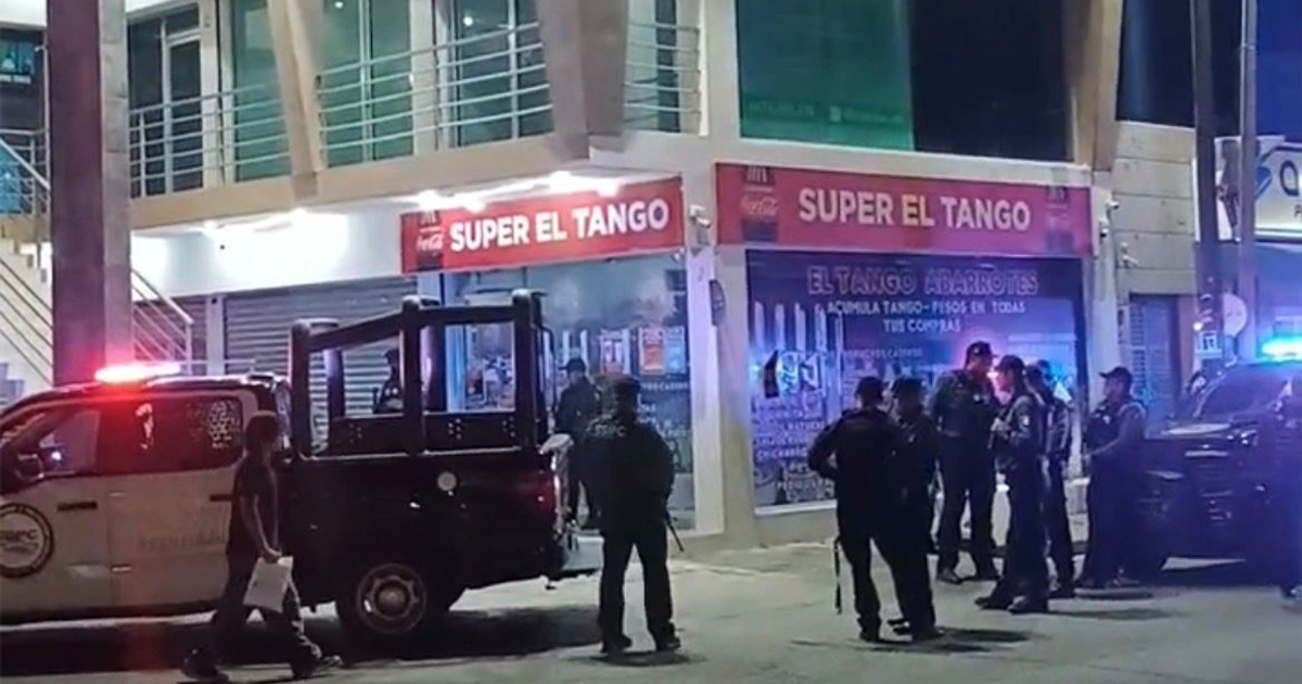 Policías reunidos de noche cerca de 'SUPER EL TANGO' en Culiacán, con camioneta de policía y luces encendidas.