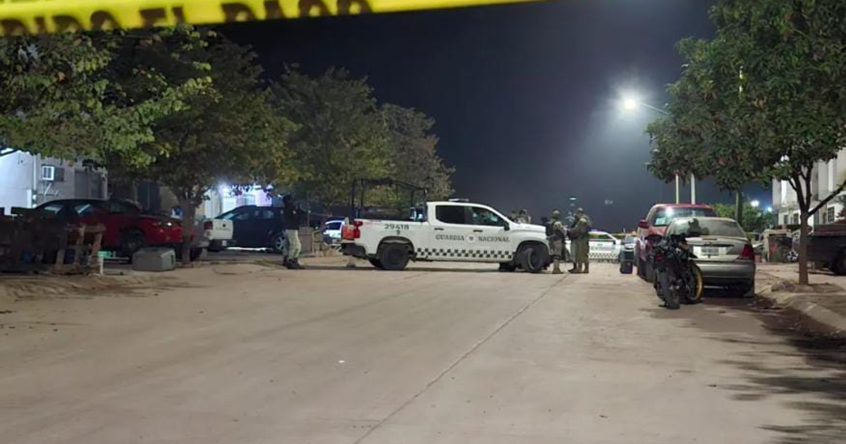 Operativo de la Guardia Nacional en una calle de Culiacán durante la noche, con agentes asegurando la escena de un crimen.