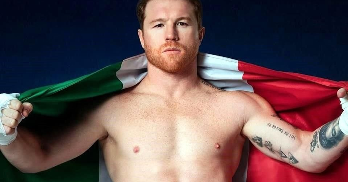 Saúl 'Canelo' Álvarez sosteniendo la bandera de México, exhibiendo sus músculos y tatuajes.