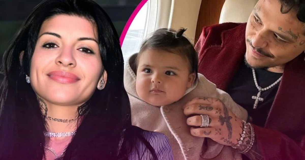 Mujer sonriendo y hombre sosteniendo a un bebé en un entorno interior